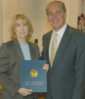 A man and woman holding a blue folder.