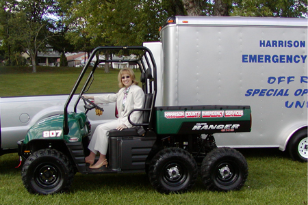 A woman sitting on the back of an all terrain vehicle.